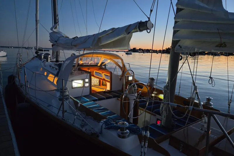 Slide: The Image of Hinckley Bermuda 40 sailboat at sunset, docked with illuminated cabin, 1970 model. - 150