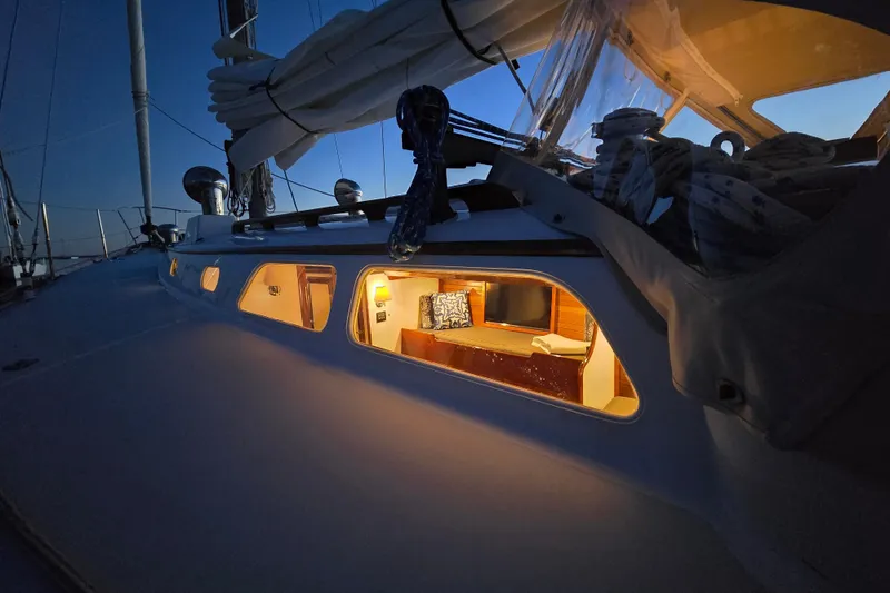 Slide: The Image of 1970 Hinckley Bermuda 40 sailboat cabin illuminated at dusk, showcasing cozy interior. - 153