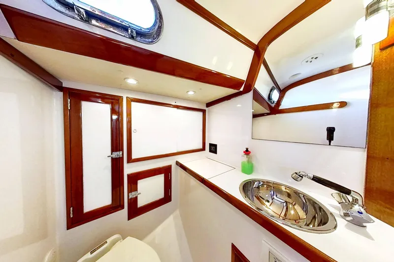 Slide: The Image of Interior of 1970 Hinckley Bermuda 40 yacht bathroom with wood accents and stainless steel sink. - 156