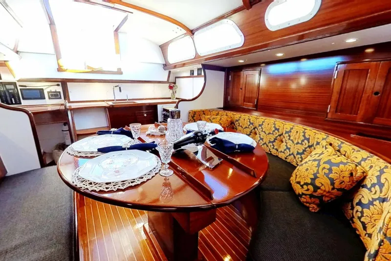 Slide: The Image of Luxurious 1970 Hinckley Bermuda 40 yacht interior with elegant dining area and wooden finishes. - 164