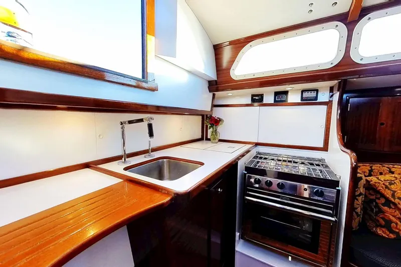 Slide: The Image of Hinckley Bermuda 40 yacht kitchen interior with stove, sink, and wooden cabinetry, 1970 model. - 169