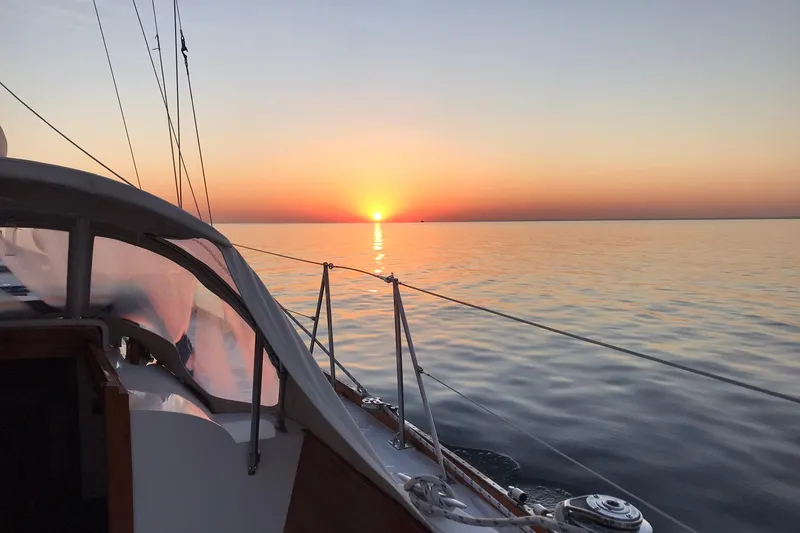 Slide: The Image of Hinckley Bermuda 40 sailboat at sunset on calm ocean waters, 1970 model. - 17