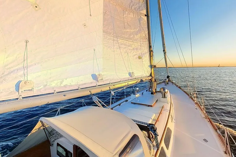 Slide: The Image of Sailing on a 1970 Hinckley Bermuda 40 yacht at sunset over calm waters. - 177