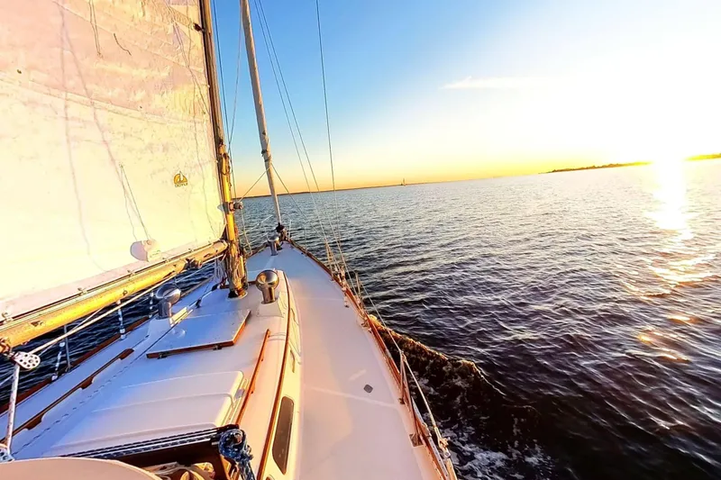 Slide: The Image of Sailing on a 1970 Hinckley Bermuda 40 yacht at sunset over calm waters. - 178