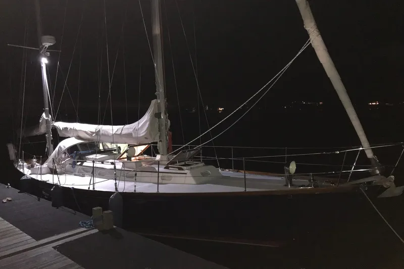 Slide: The Image of 1970 Hinckley Bermuda 40 sailboat docked at night, illuminated by deck lights. - 18