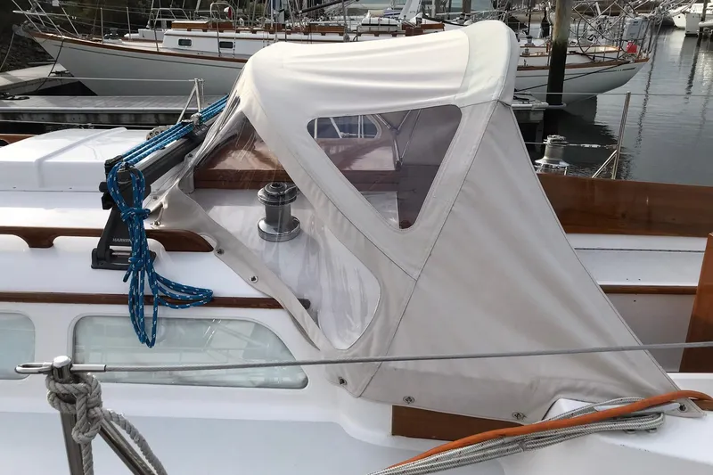 Slide: The Image of 1970 Hinckley Bermuda 40 sailboat with protective canopy and blue ropes at a marina. - 19
