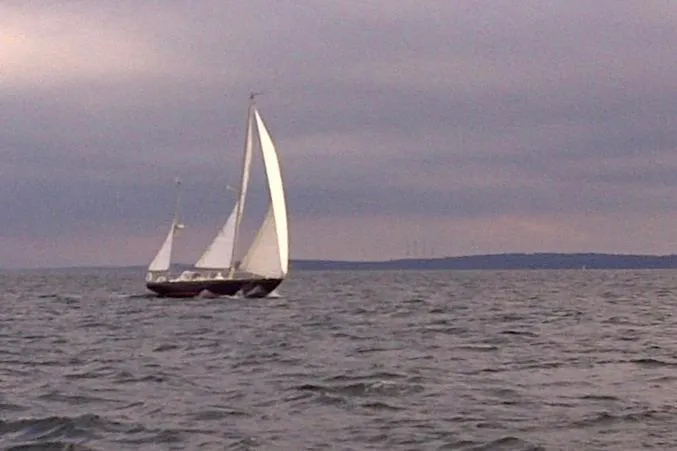 Slide: The Image of Sailing yacht Hinckley Bermuda 40 from 1970 on open water under cloudy skies. - 2