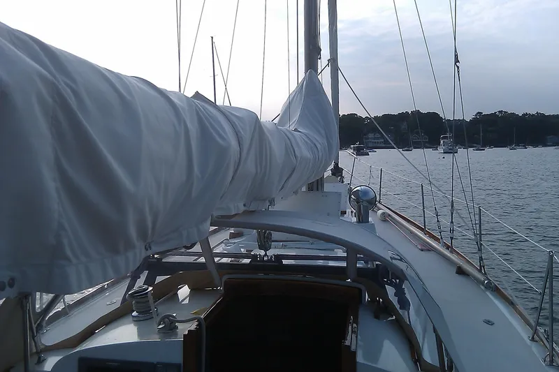 Slide: The Image of 1970 Hinckley Bermuda 40 sailboat deck view, moored in a serene harbor. - 20