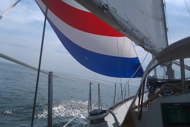 Slide: The Image of Hinckley Bermuda 40 sailboat from 1970 with colorful spinnaker on open sea. - 21