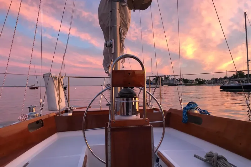 Slide: The Image of Hinckley Bermuda 40 sailboat at sunset, 1970 model, with vibrant pink sky and calm waters. - 22