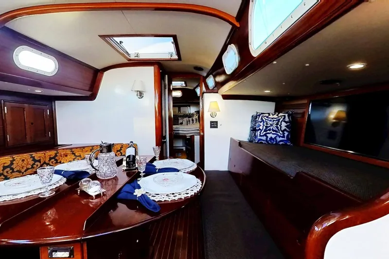 Slide: The Image of Interior of a 1970 Hinckley Bermuda 40 yacht, featuring elegant dining setup and cozy seating. - 23