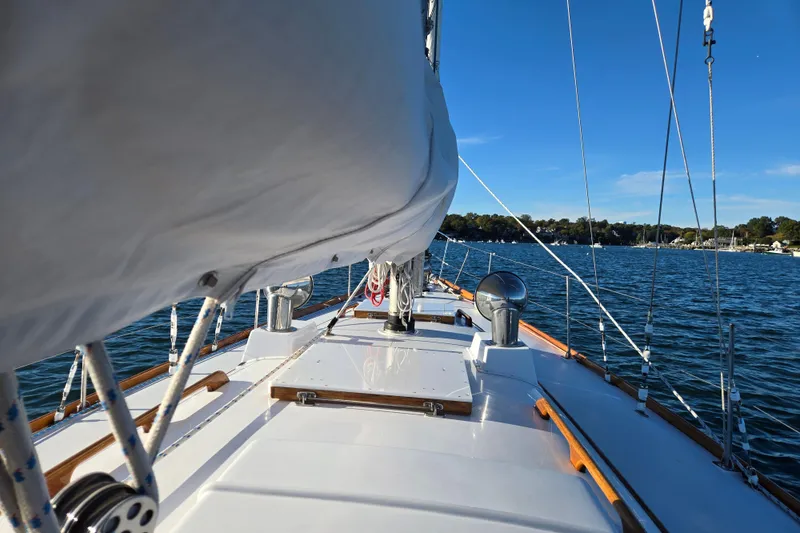 Slide: The Image of 1970 Hinckley Bermuda 40 sailboat on calm waters under clear blue sky. - 39