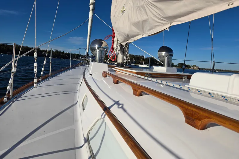 Slide: The Image of 1970 Hinckley Bermuda 40 sailboat deck with wooden accents and rigging, sailing on a sunny day. - 48
