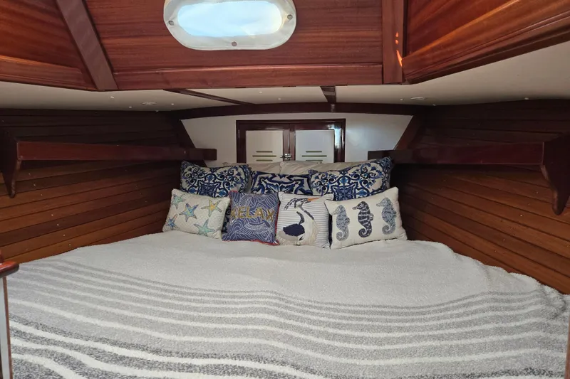 Slide: The Image of Cozy cabin interior of a 1970 Hinckley Bermuda 40 sailboat with nautical-themed pillows. - 63