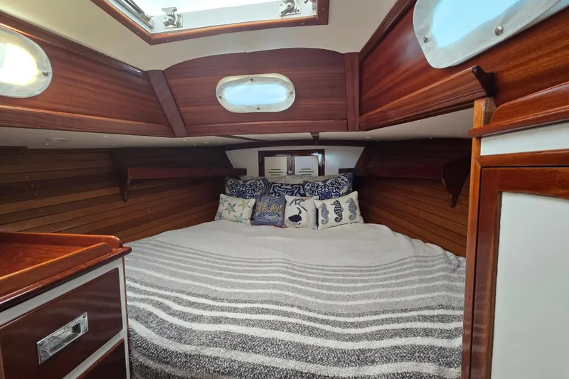 Slide: The Image of Cozy cabin interior of a 1970 Hinckley Bermuda 40 sailboat with striped bedding. - 64