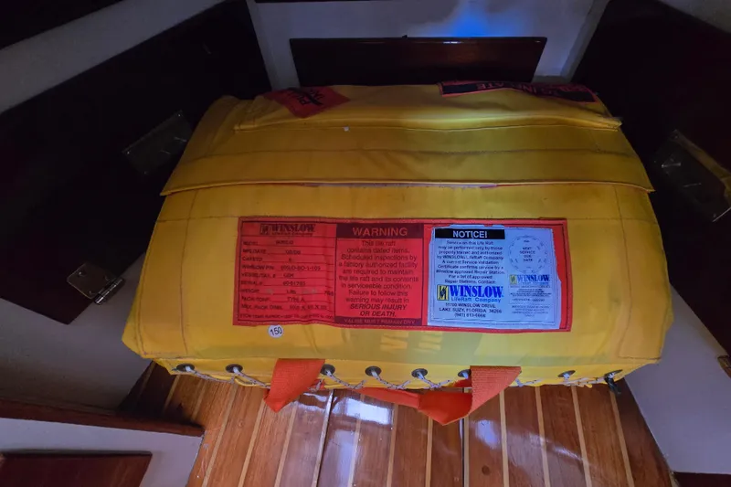 Slide: The Image of Yellow Winslow life raft on 1970 Hinckley Bermuda 40 yacht, featuring safety warnings and notices. - 66