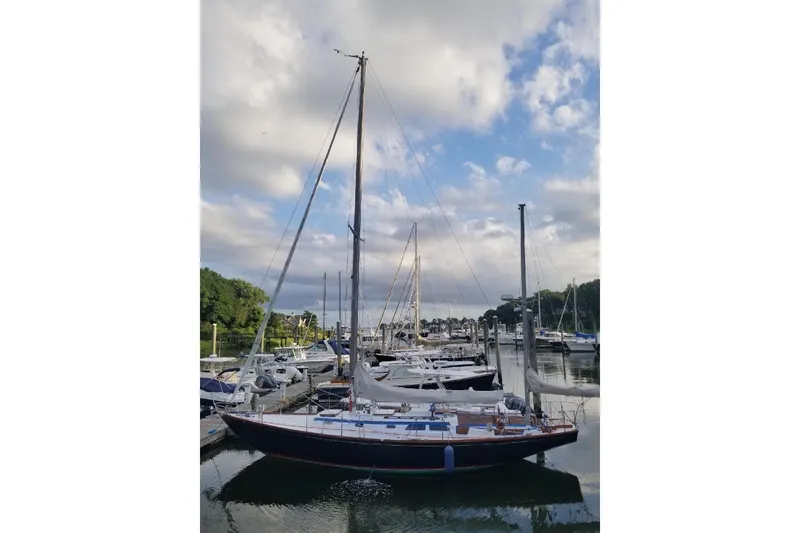 Slide: The Image of 1970 Hinckley Bermuda 40 sailboat docked in a marina under a partly cloudy sky. - 7