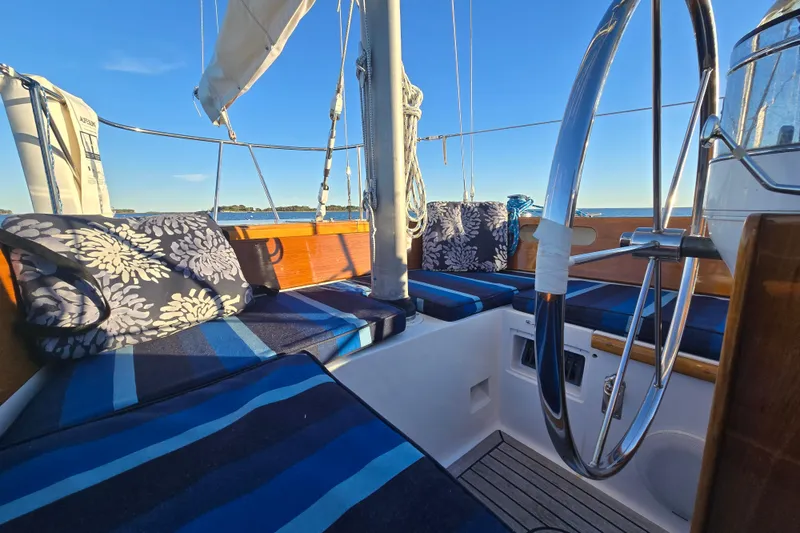 Slide: The Image of Cockpit of a 1970 Hinckley Bermuda 40 sailboat with striped cushions and a steering wheel. - 76