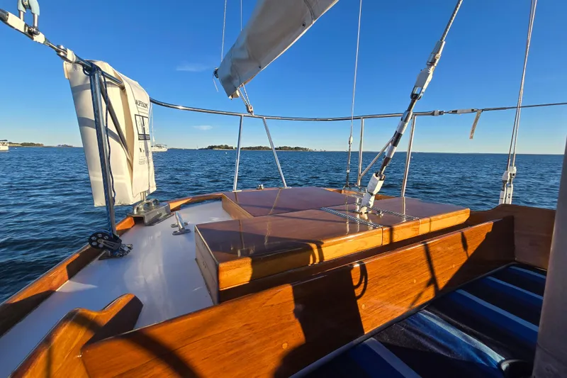 Slide: The Image of 1970 Hinckley Bermuda 40 sailboat deck with ocean view under clear blue sky. - 77