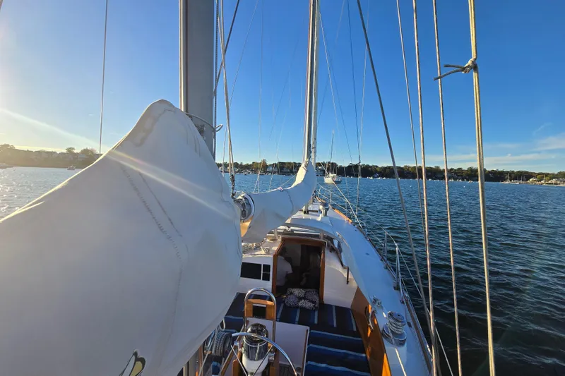 Slide: The Image of 1970 Hinckley Bermuda 40 sailboat on calm water under clear blue sky. - 79