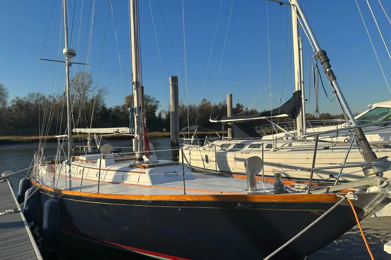 Slide: The Image of 1970 Hinckley Bermuda 40 sailboat docked at marina under clear blue sky. - 8