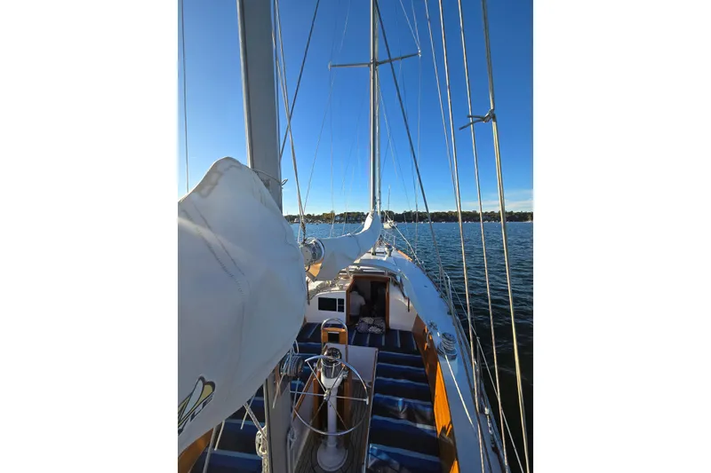 Slide: The Image of 1970 Hinckley Bermuda 40 sailboat on calm water under clear blue sky. - 80