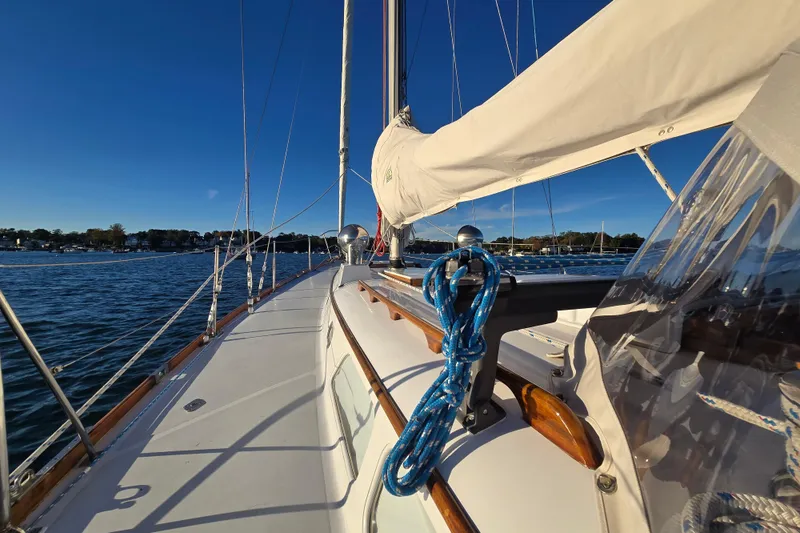 Slide: The Image of 1970 Hinckley Bermuda 40 sailboat deck with blue ropes, sailing on calm waters. - 83