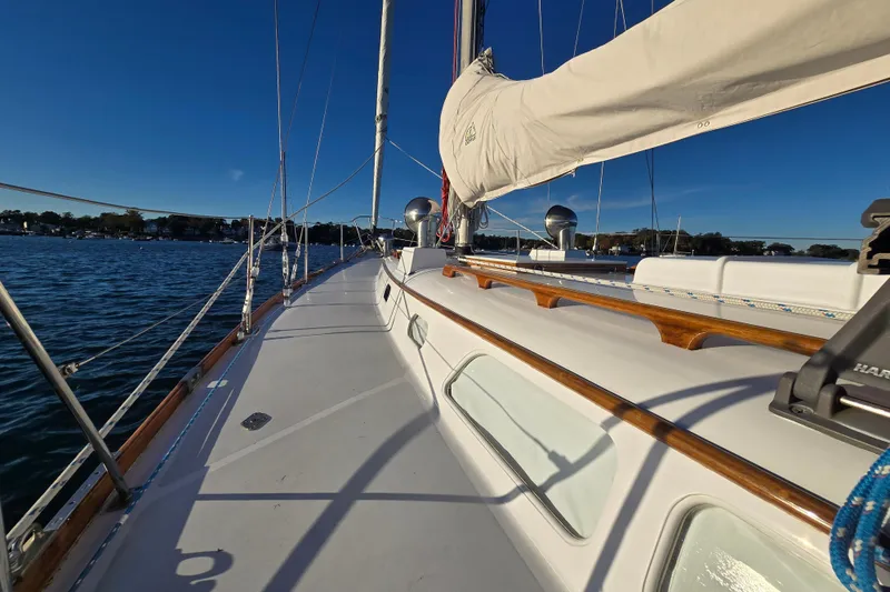 Slide: The Image of 1970 Hinckley Bermuda 40 sailboat deck with clear skies and calm waters. - 84