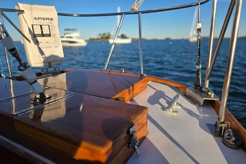 Slide: The Image of 1970 Hinckley Bermuda 40 sailboat deck with polished wood and ocean view. - 88