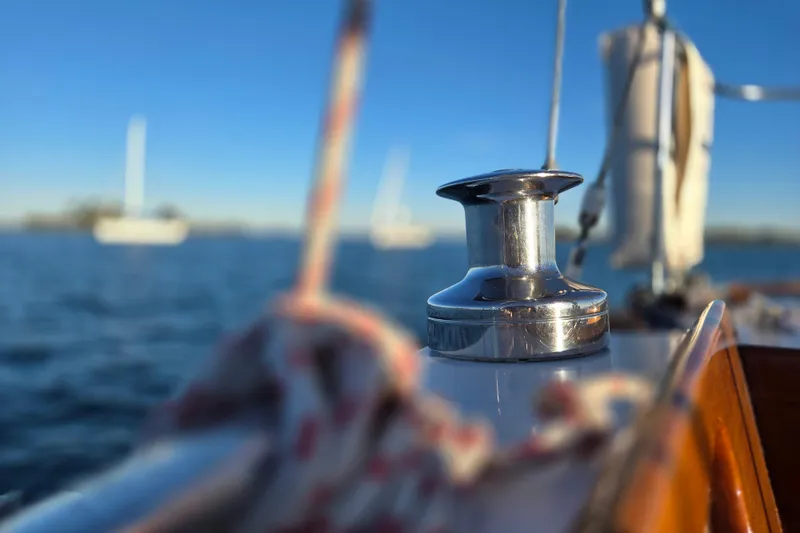 Slide: The Image of Close-up of a winch on a 1970 Hinckley Bermuda 40 sailboat, with blurred ocean background. - 89