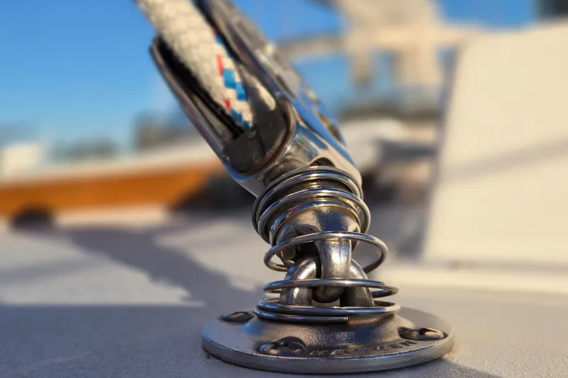 Slide: The Image of Close-up of a Hinckley Bermuda 40 sailboat's deck fitting, showcasing polished metal and rope detail. - 93