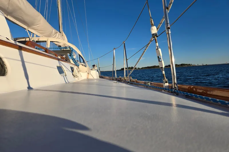 Slide: The Image of 1970 Hinckley Bermuda 40 sailboat deck with ocean view under clear blue sky. - 98