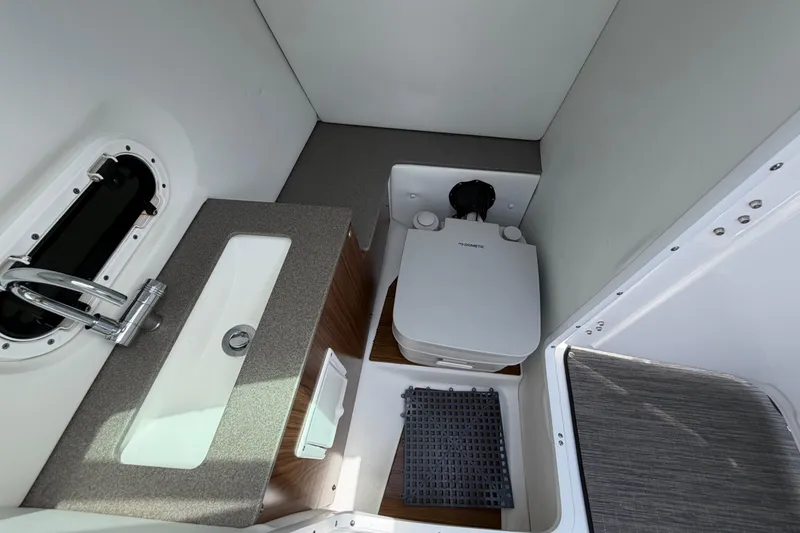 Slide: The Image of 2022 Four Winns HD8 OB boat bathroom with sink and compact toilet. - 15