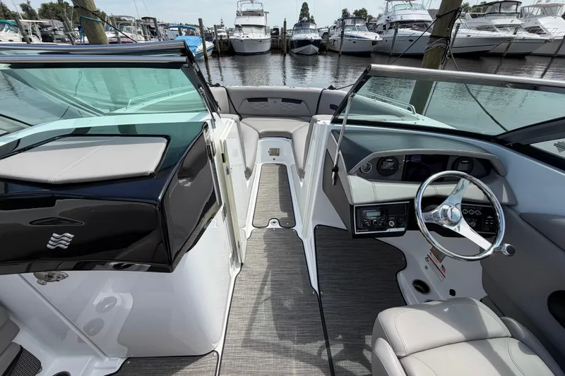 Slide: The Image of 2022 Four Winns HD8 OB boat interior with steering wheel and seating at marina. - 18