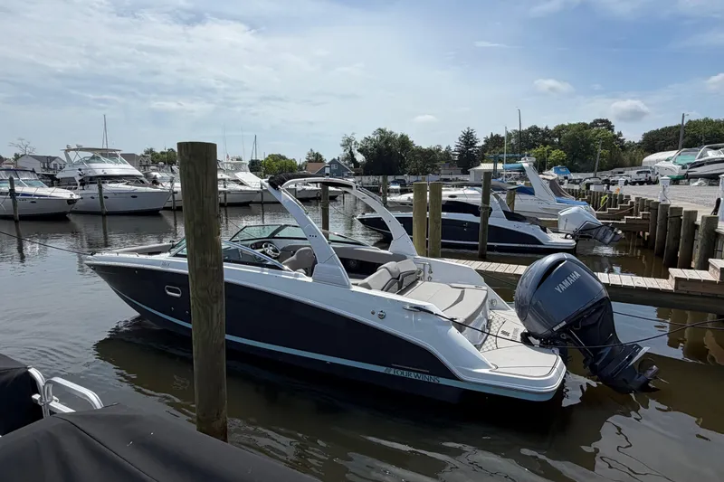 Slide: The Image of 2022 Four Winns HD8 OB boat docked in a marina with other vessels. - 5