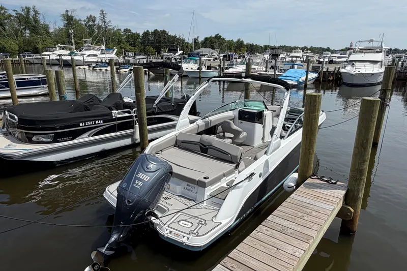 Slide: The Image of 2022 Four Winns HD8 OB boat docked at a marina with other vessels. - 7