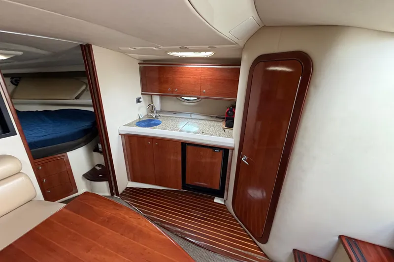 Slide: The Image of Interior of a 2007 Monterey 350 Sport Yacht featuring a compact kitchen and cozy sleeping area. - 15