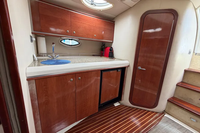 Slide: The Image of 2007 Monterey 350 Sport Yacht interior with wooden cabinetry, compact kitchenette, and sleek design. - 17