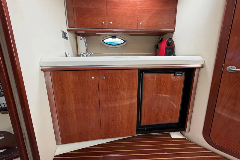 Slide: The Image of Interior of 2007 Monterey 350 Sport Yacht with wooden cabinetry and compact kitchenette. - 18