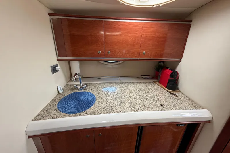 Slide: The Image of Compact kitchen area in a 2007 Monterey 350 Sport Yacht with wooden cabinets and granite countertop. - 19