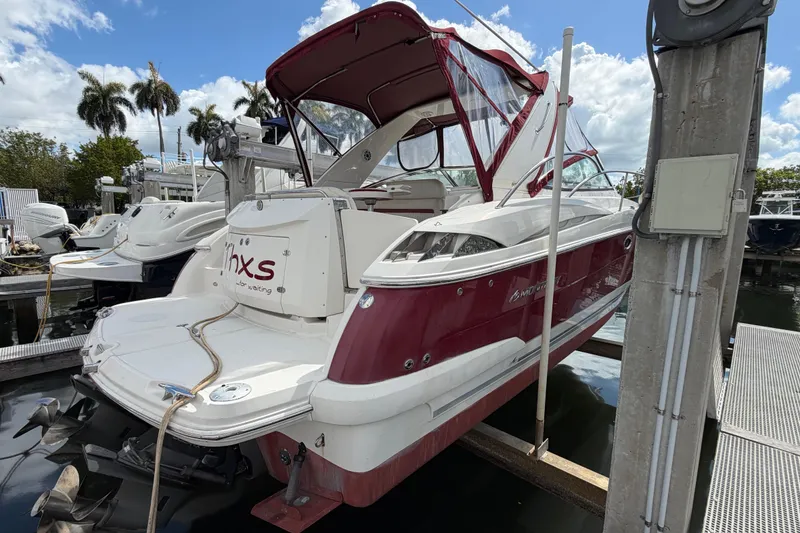 Slide: The Image of 2007 Monterey 350 Sport Yacht docked, featuring red and white exterior with canopy. - 2