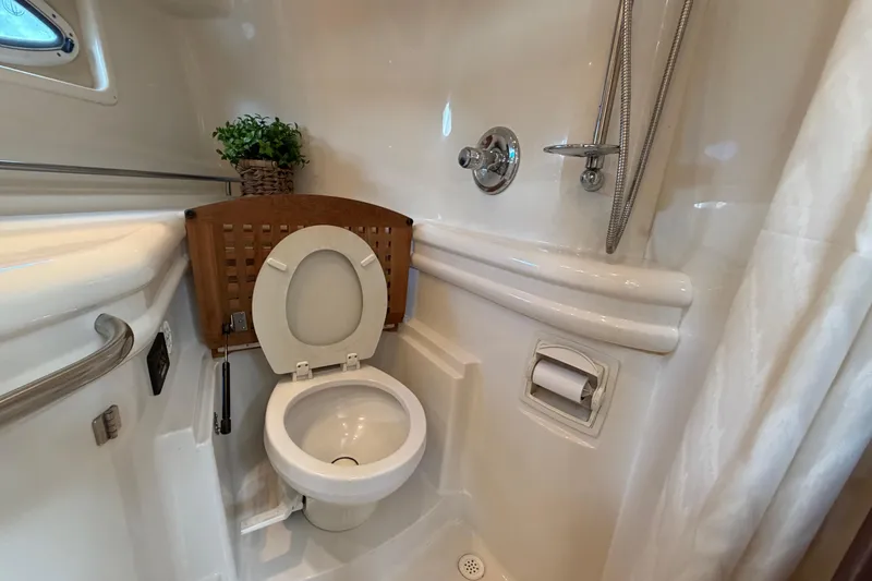 Slide: The Image of 2007 Monterey 350 Sport Yacht bathroom with toilet, shower, and porthole window. - 26