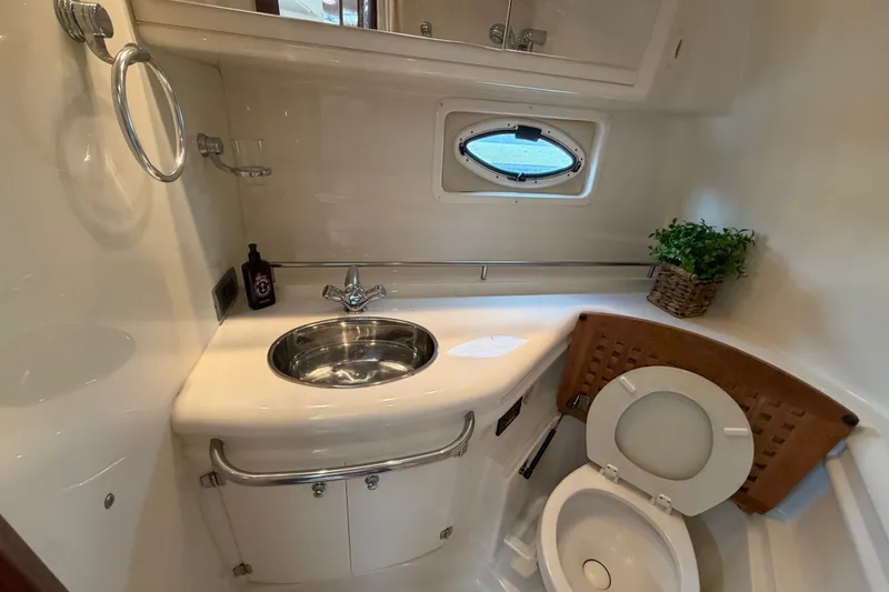 Slide: The Image of 2007 Monterey 350 Sport Yacht bathroom with sink, toilet, and porthole window. - 27