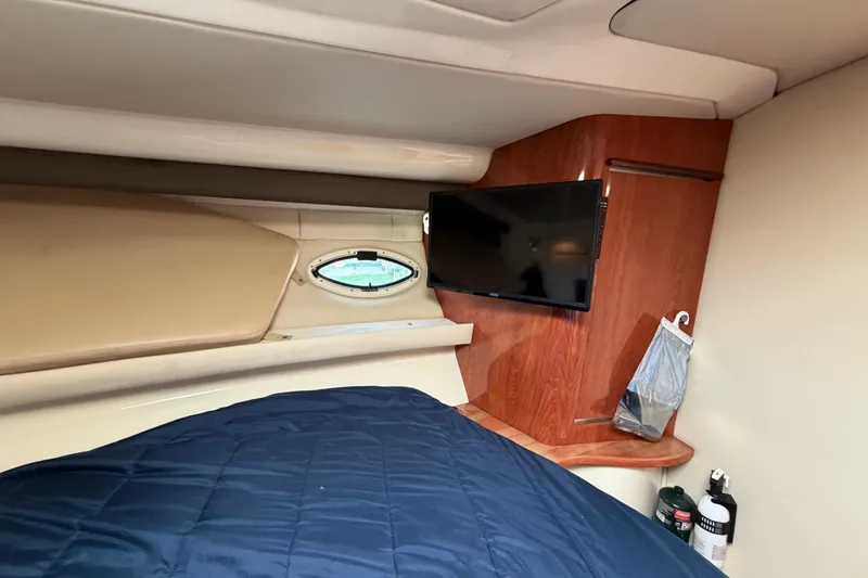Slide: The Image of Interior of 2007 Monterey 350 Sport Yacht with TV, porthole, and blue bedding. - 32