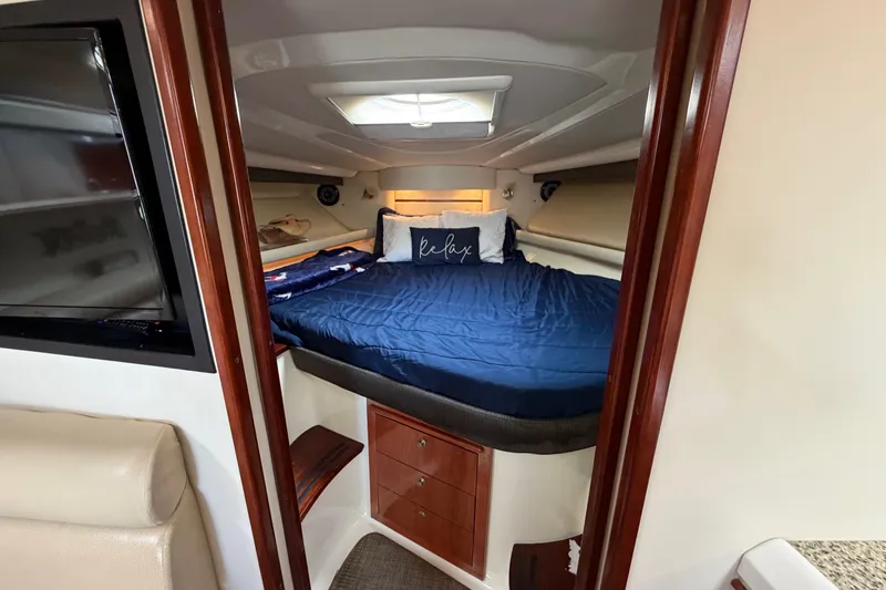 Slide: The Image of Cozy cabin interior of 2007 Monterey 350 Sport Yacht with blue bedding and TV. - 33