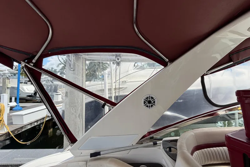 Slide: The Image of Interior view of a 2007 Monterey 350 Sport Yacht with maroon canopy and docked boats outside. - 53