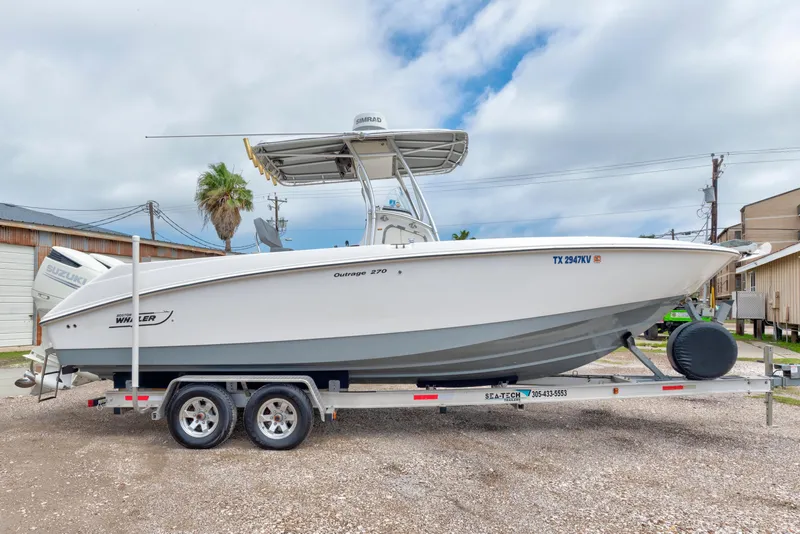 Slide: The Image of 2003 Boston Whaler 270 Outrage boat on trailer, parked outdoors. - 1