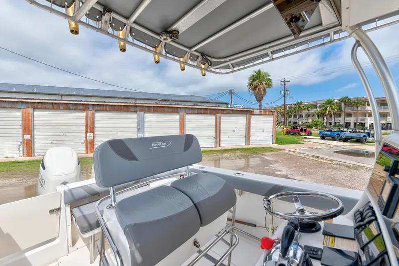 Slide: The Image of 2003 Boston Whaler 270 Outrage boat interior with helm, seating, and storage area. - 10