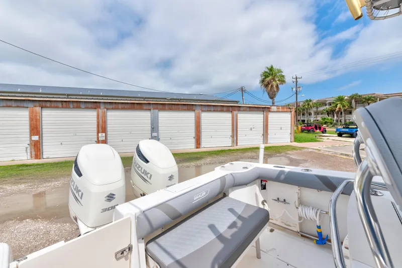 Slide: The Image of 2003 Boston Whaler 270 Outrage boat with Suzuki engines, parked near storage units. - 12