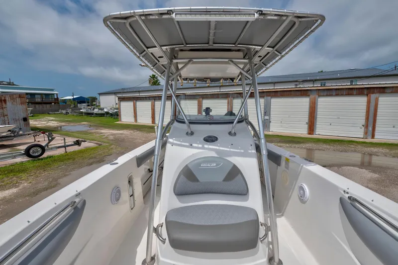 Slide: The Image of 2003 Boston Whaler 270 Outrage boat with T-top, docked near storage units. - 16